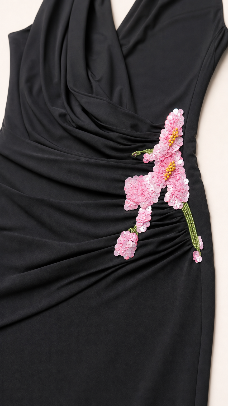 Close-up detail of the floral applique and draping on black dress