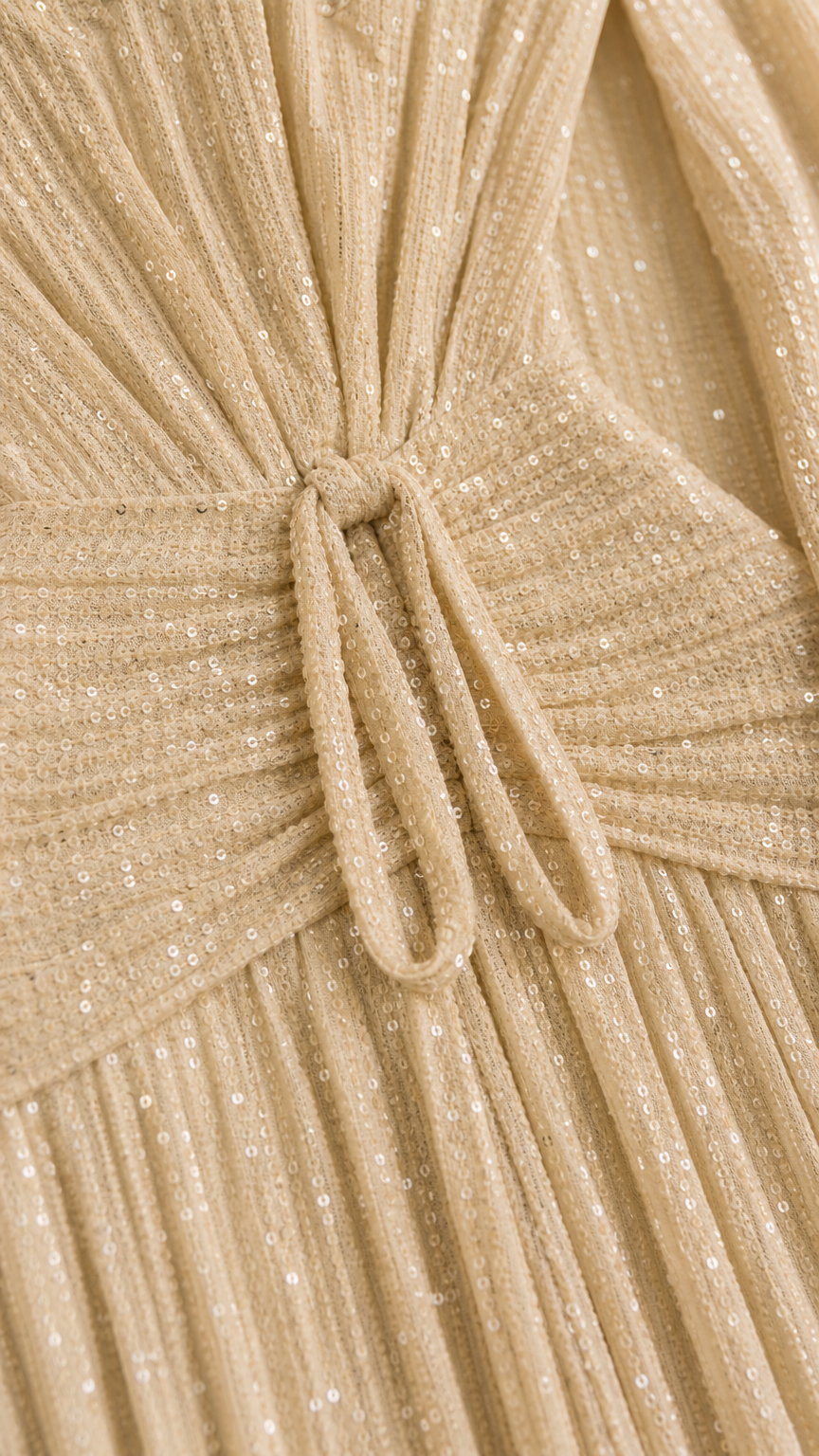 Close-up detail of champagne pleated shimmer fabric and knotted front tie