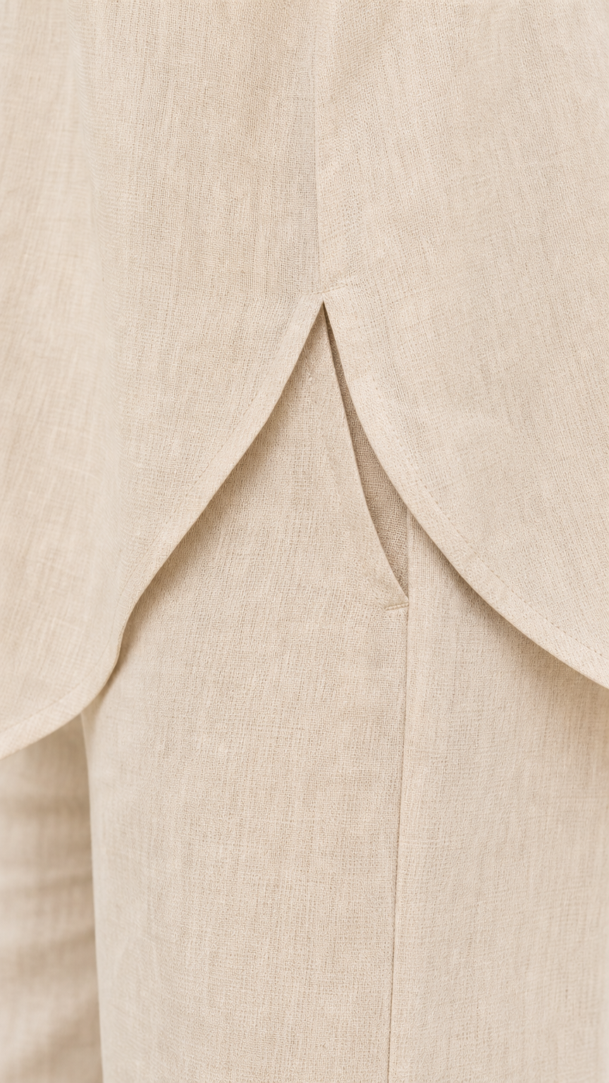 Close-up detail of back split hem on beige shirt and pants