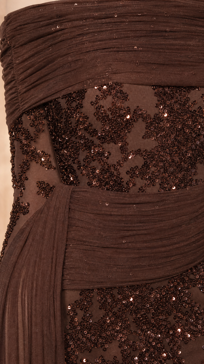Close up of pleated bodice and sequin detail on brown evening gown