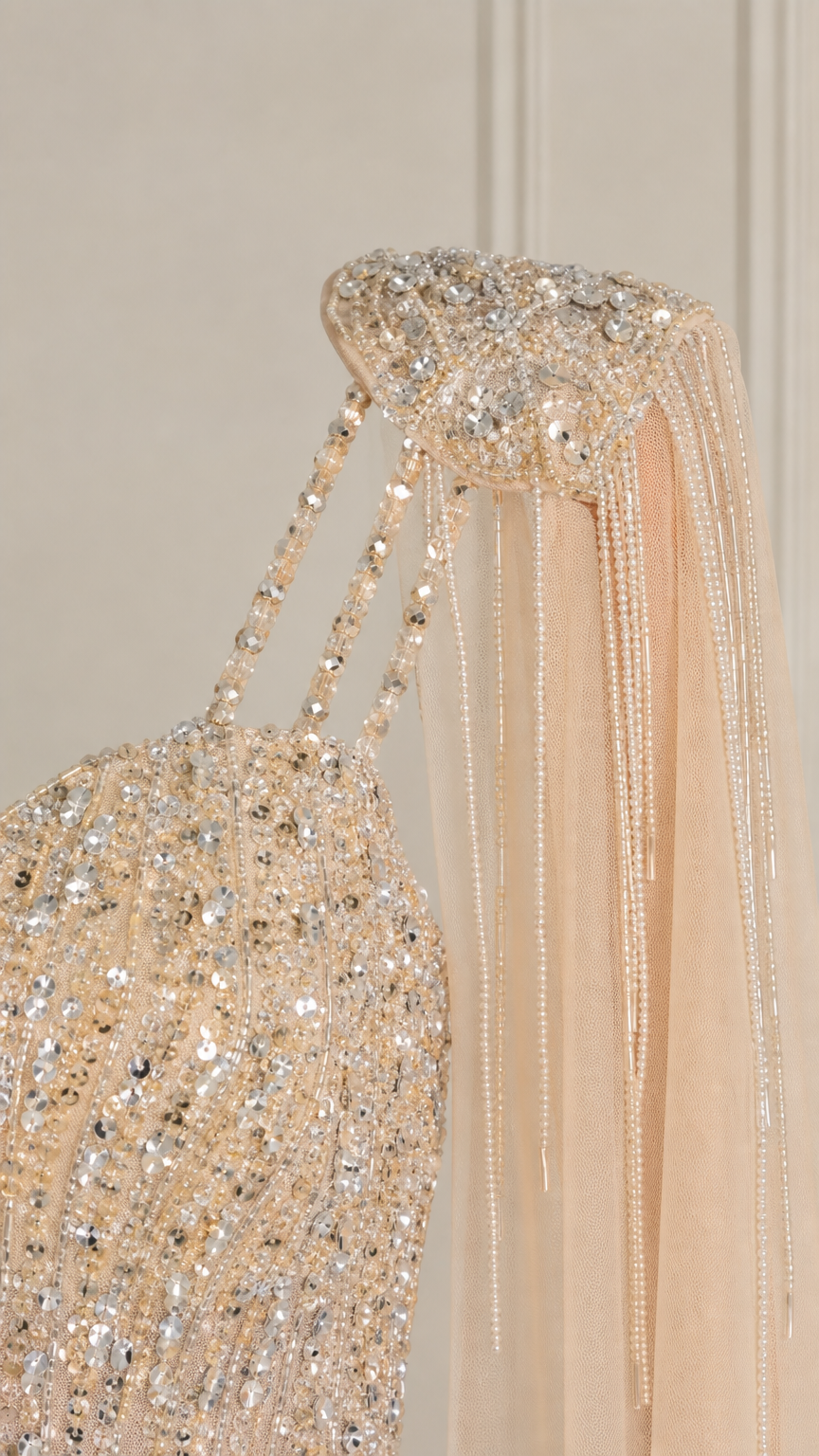 Close-up detail of crystal beading and fringe epaulettes on dress shoulder