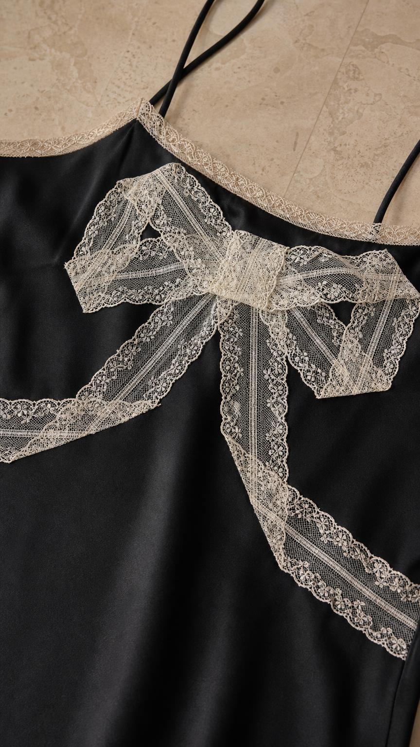 Close-up detail of lace bow and neckline on black dress