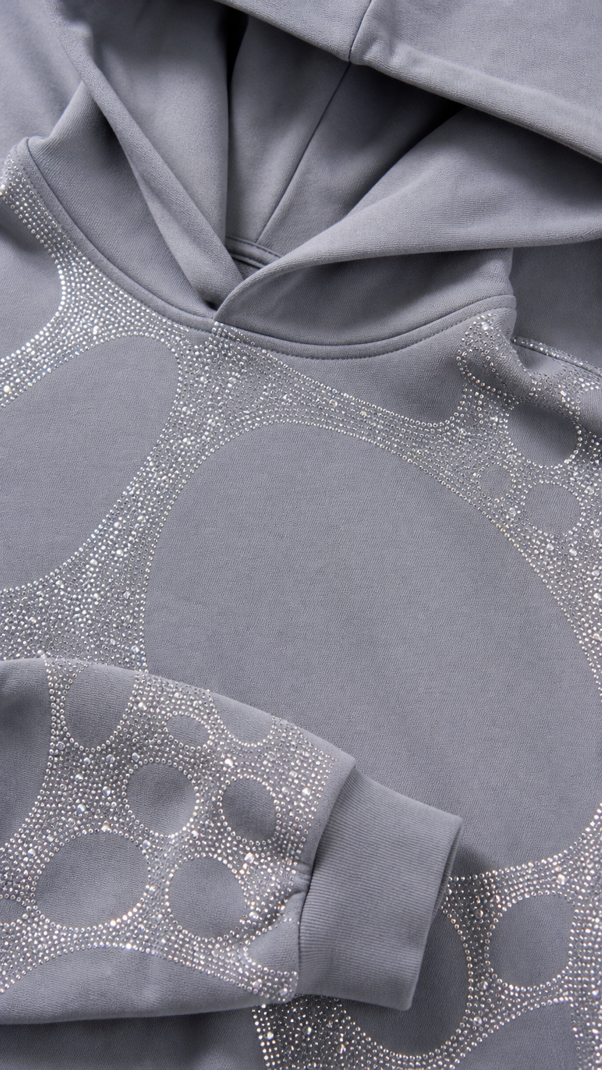 Close-up detail of grey hoodie hood and rhinestone graphic fabric