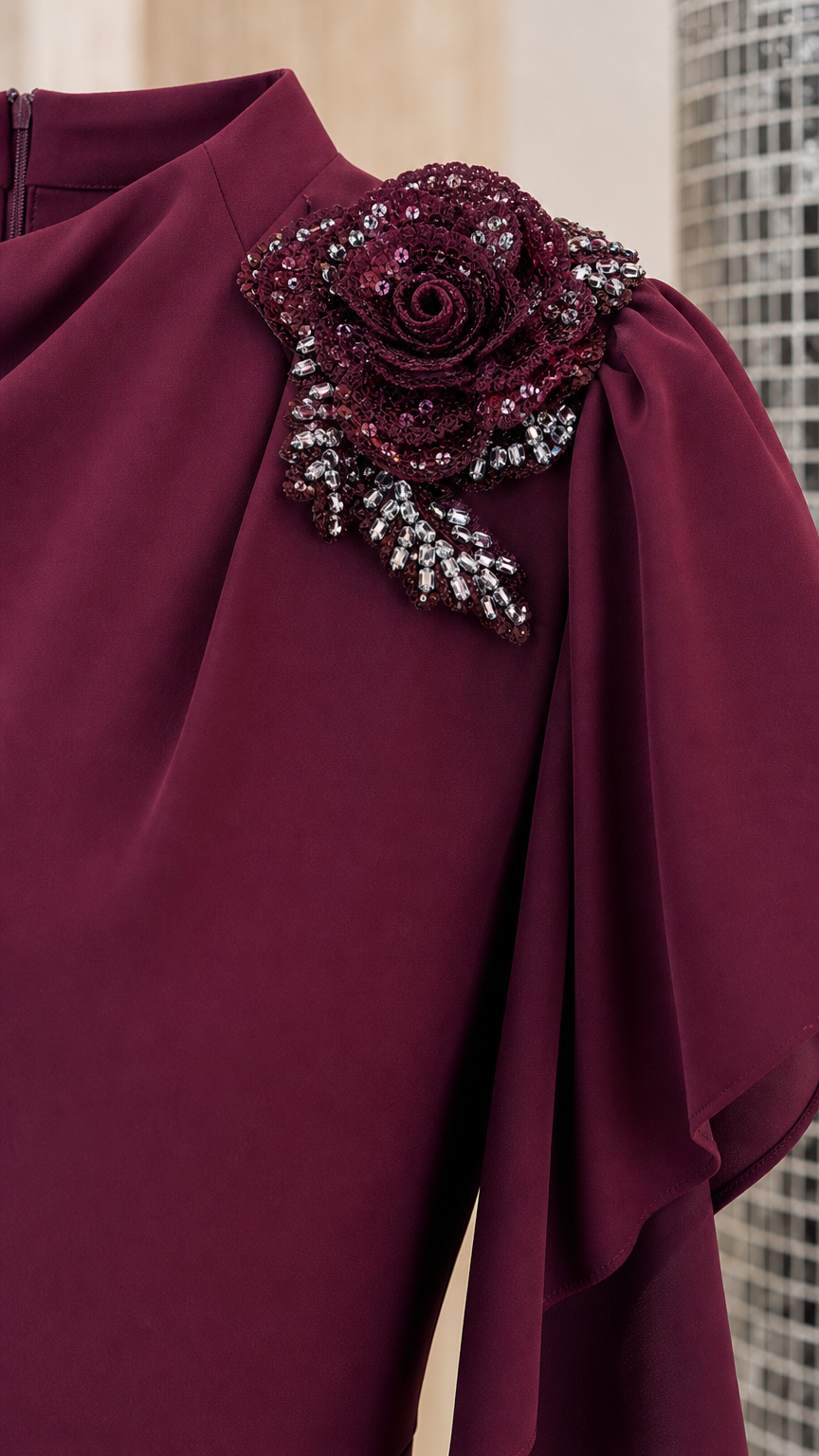 Close-up of beaded flower embellishment and gathered high neck on burgundy gown