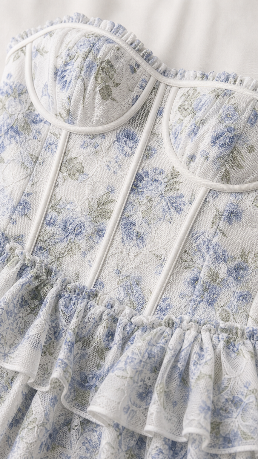 Close-up detail of white and blue floral bustier bodice with ruffles