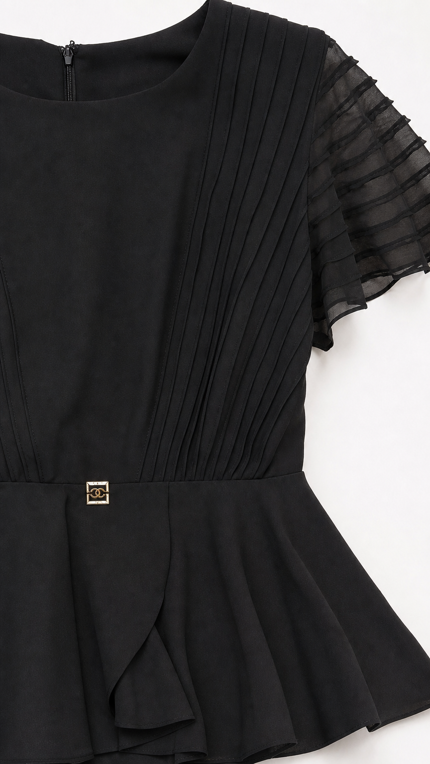 Close-up detail of pleated bodice and peplum accent on black dress