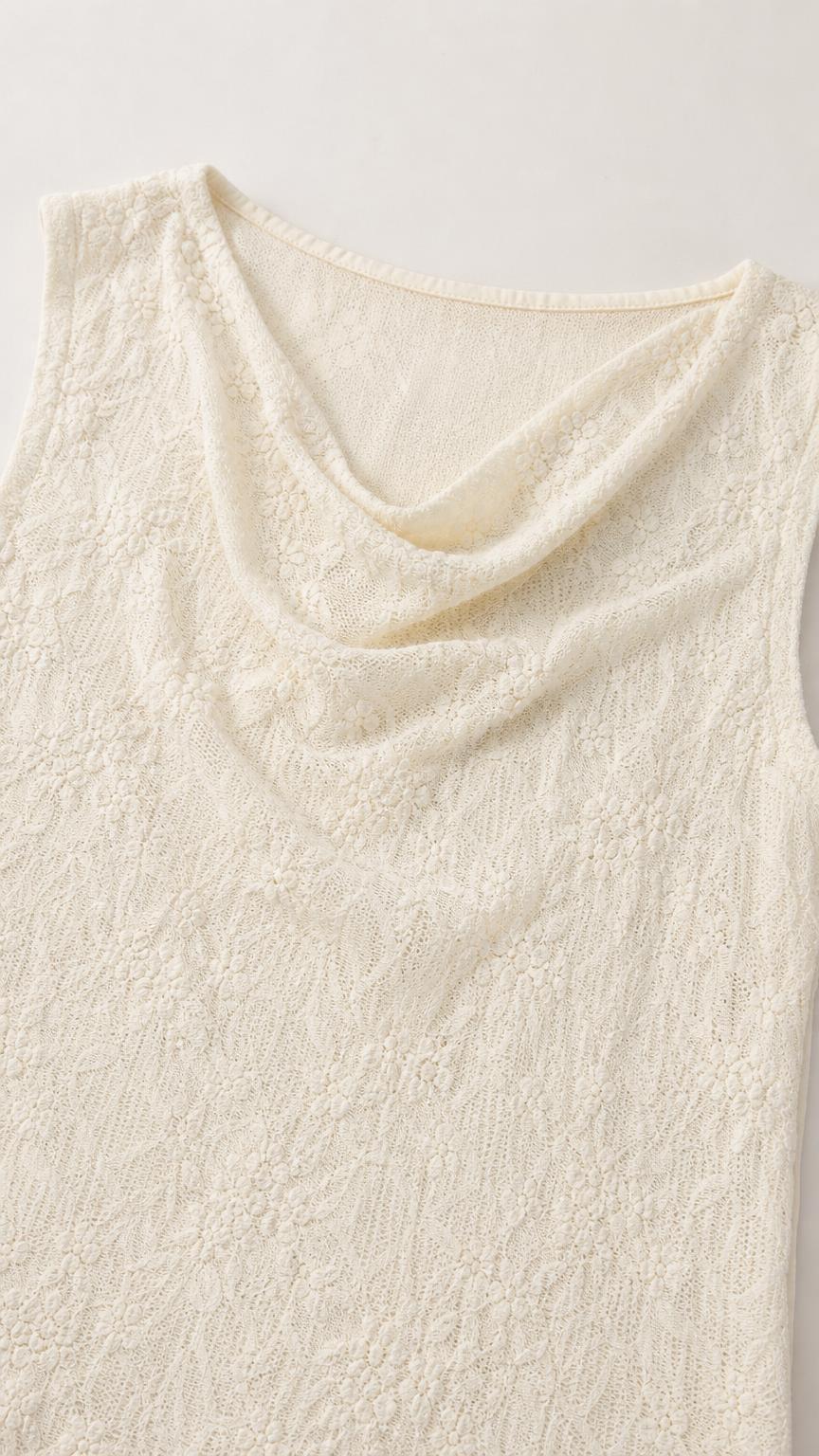 Close-up detail of cream lace fabric and cowl neckline