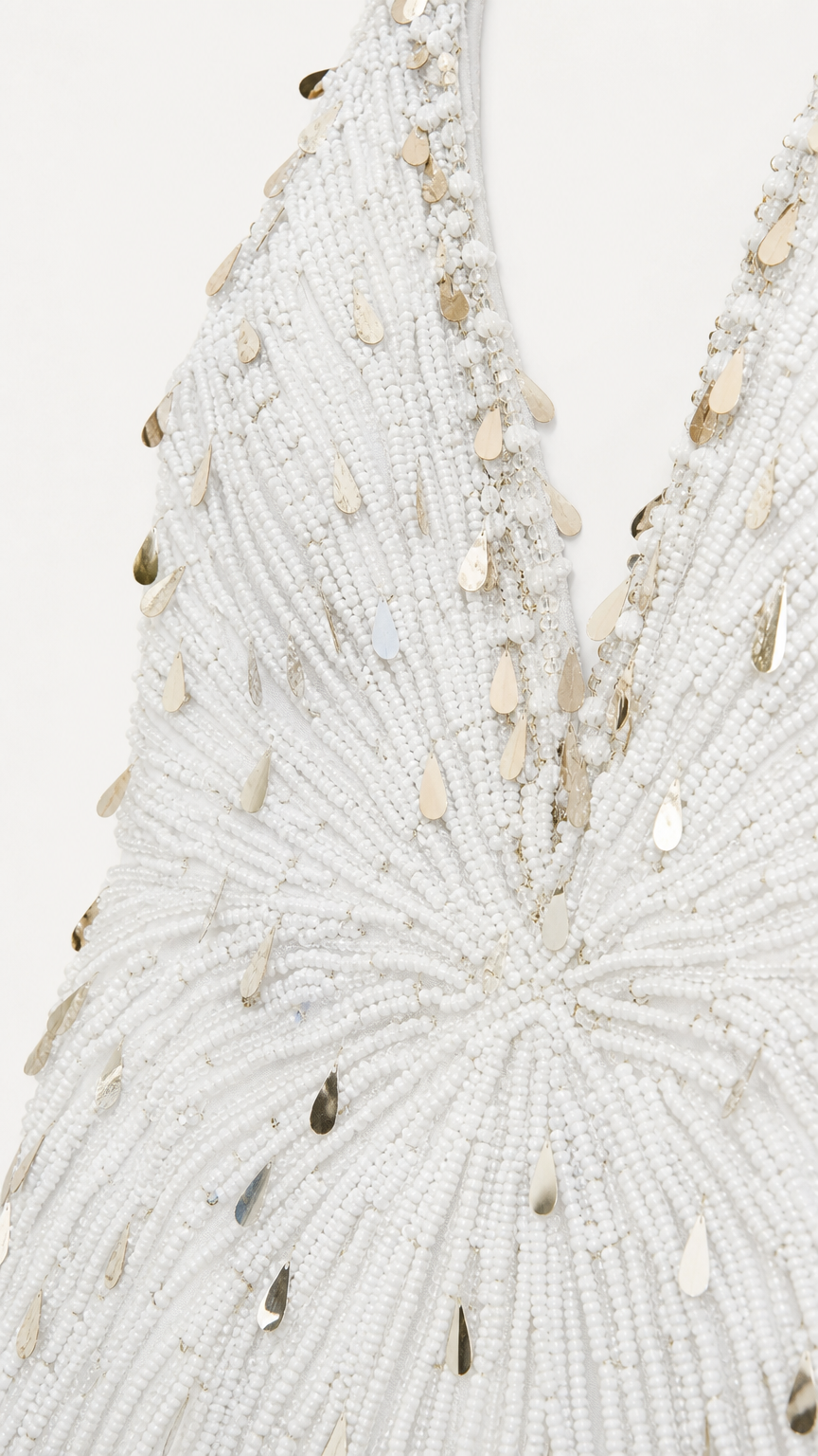 Close-up detail of intricate white seed bead and gold teardrop sequin embroidery