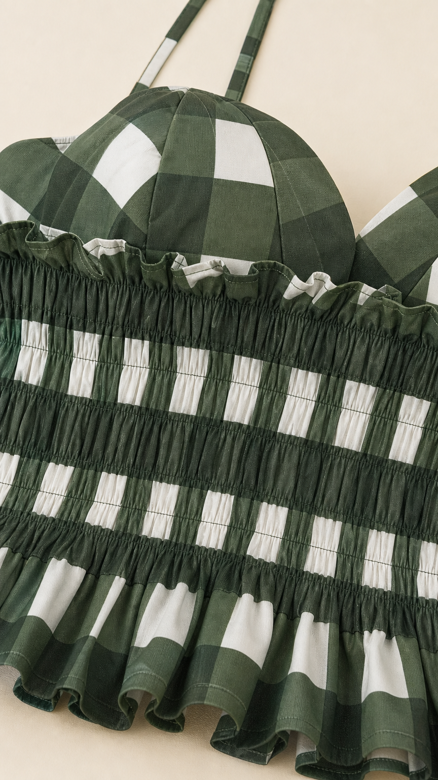 Close up of green gingham smocked bodice and straps