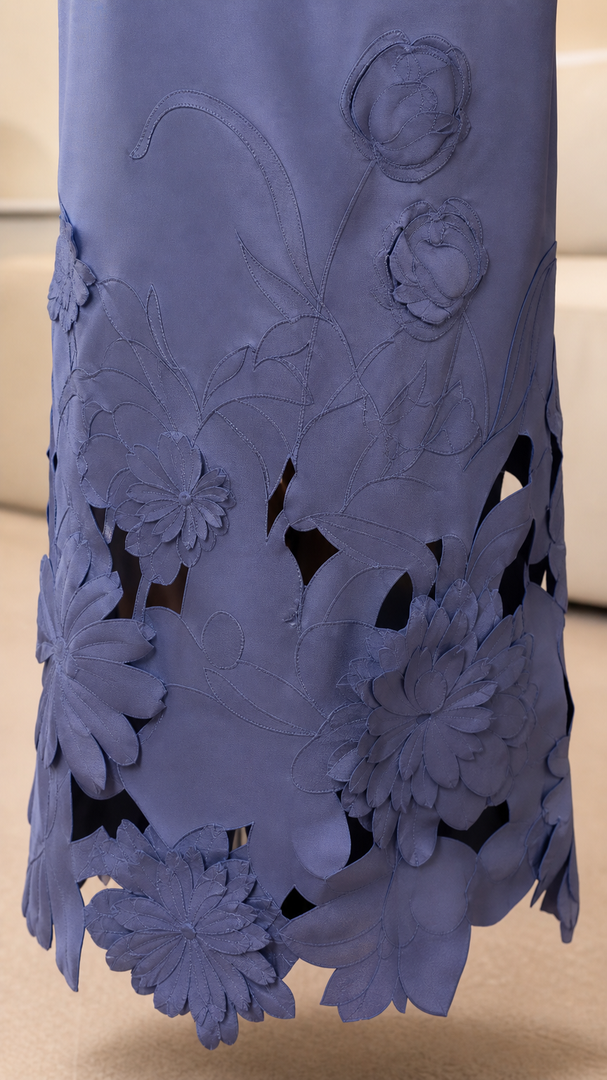 Close-up detail of the laser-cut floral hem on periwinkle dress