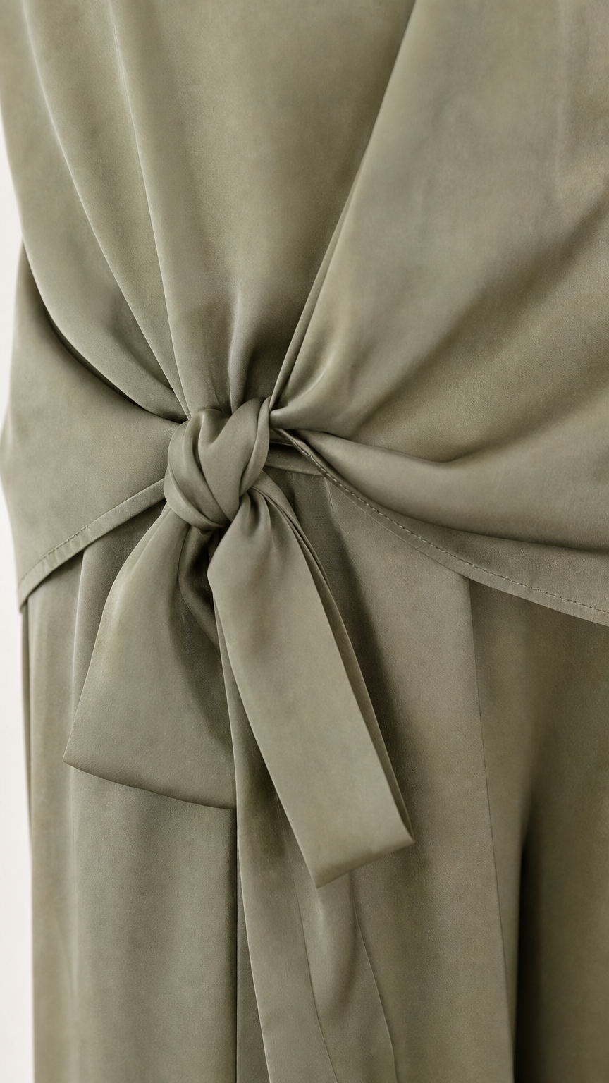 Close up of side tie detail on sage green satin pants
