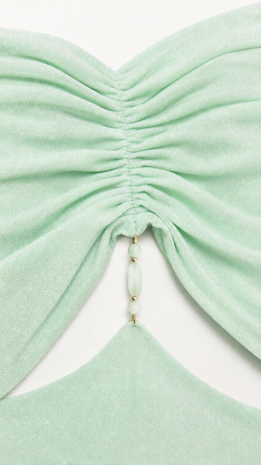 Close-up of ruched bodice and beaded detail on mint green dress