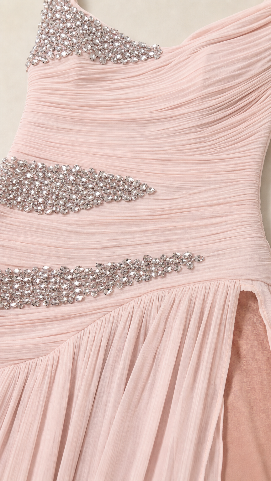 Close-up detail of delicate pink ruched chiffon fabric and sparkling rhinestone embellishments