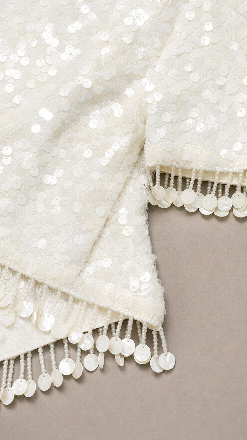Close-up of white sequin fabric and fringe trim