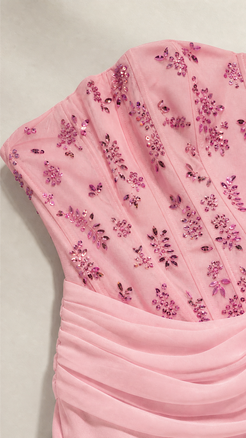 Close-up of pink beaded corset bodice with floral sequin embroidery and draped waistband
