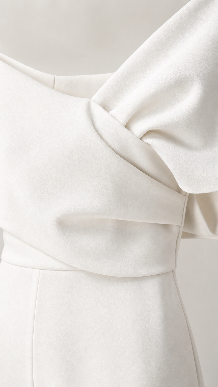 Close-up detail of draped bodice and fabric on white jumpsuit