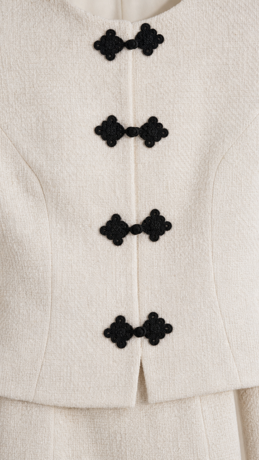 Close-up detail of textured fabric and decorative black knot closures