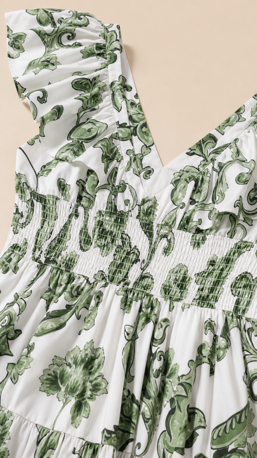 Close up of ruffle shoulder and smocked bodice detail on white floral dress
