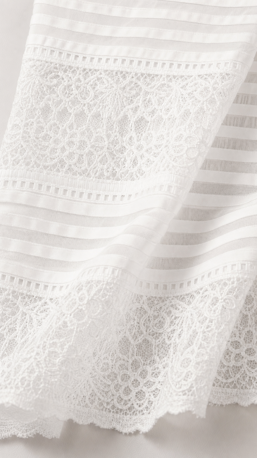Close-up detail of white lace and striped fabric texture