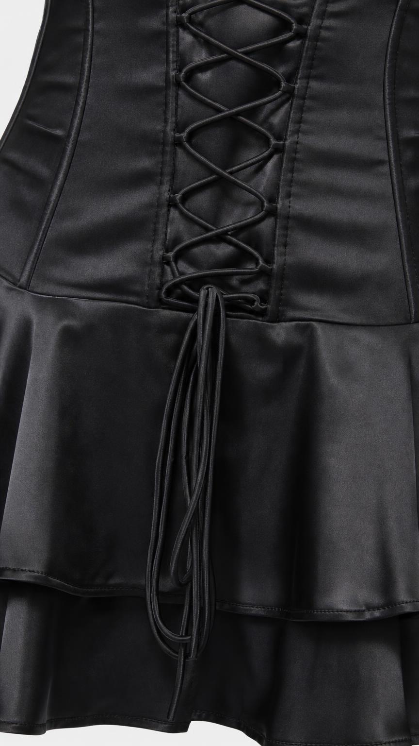 Close-up of lace-up corset detail and ruffled hem on black dress
