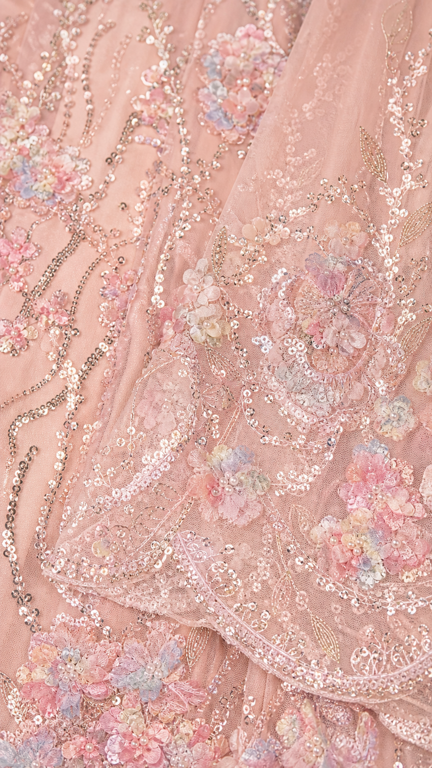 Close-up detail of delicate floral sequin and bead embroidery on mesh fabric