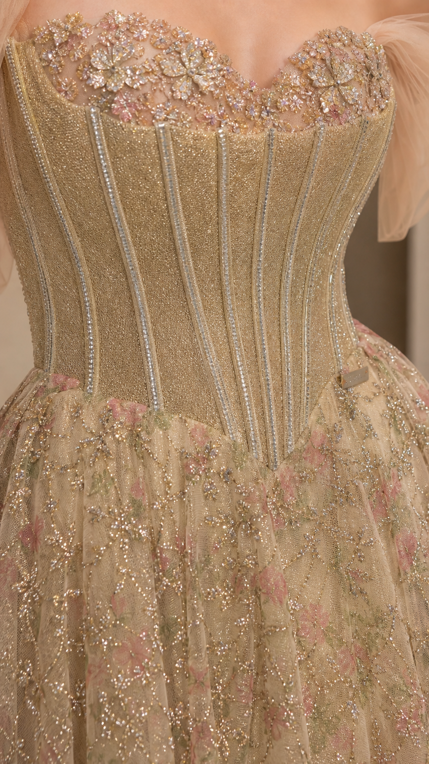 Close-up detail of champagne gold corset bodice with floral neckline embroidery and boning