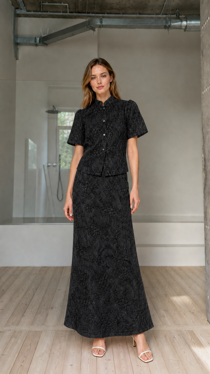 Model wearing black floral embroidered short-sleeve top and maxi skirt matching set