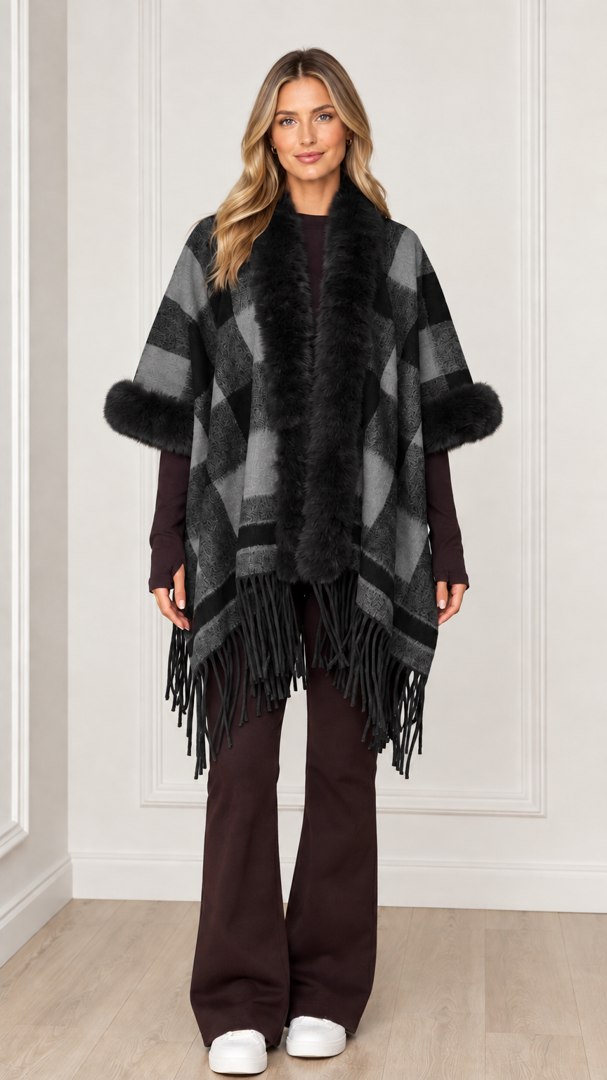 Woman wearing charcoal grey plaid poncho wrap with black faux fur trim
