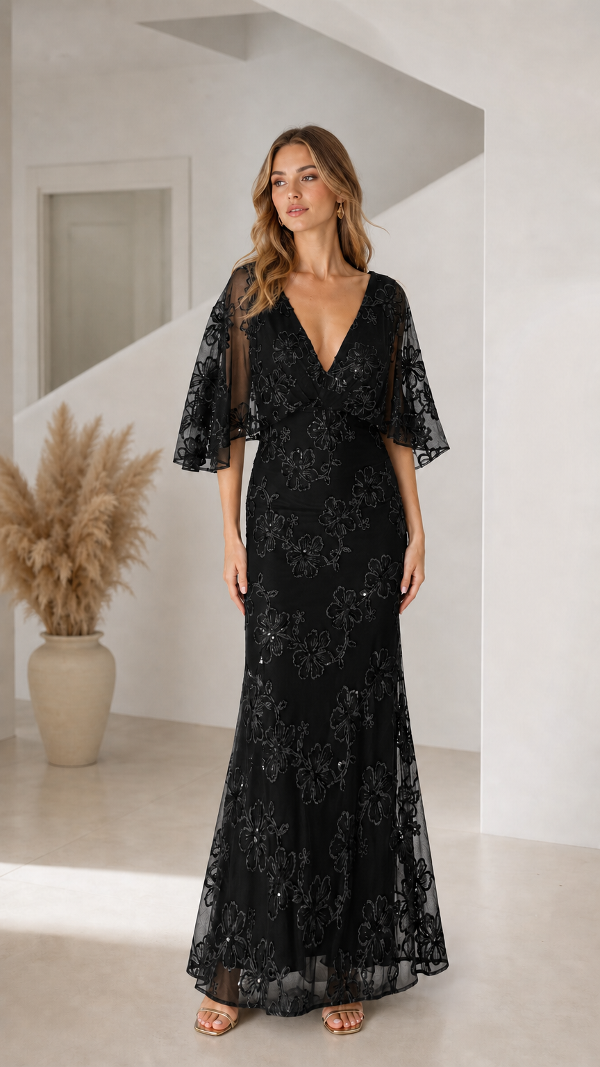 Front view of woman wearing black floral sequin flutter sleeve evening maxi dress