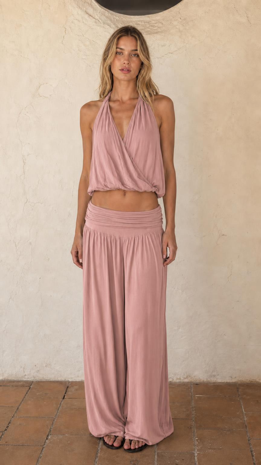 Woman wearing dusty pink halter crop top and wide leg pants set
