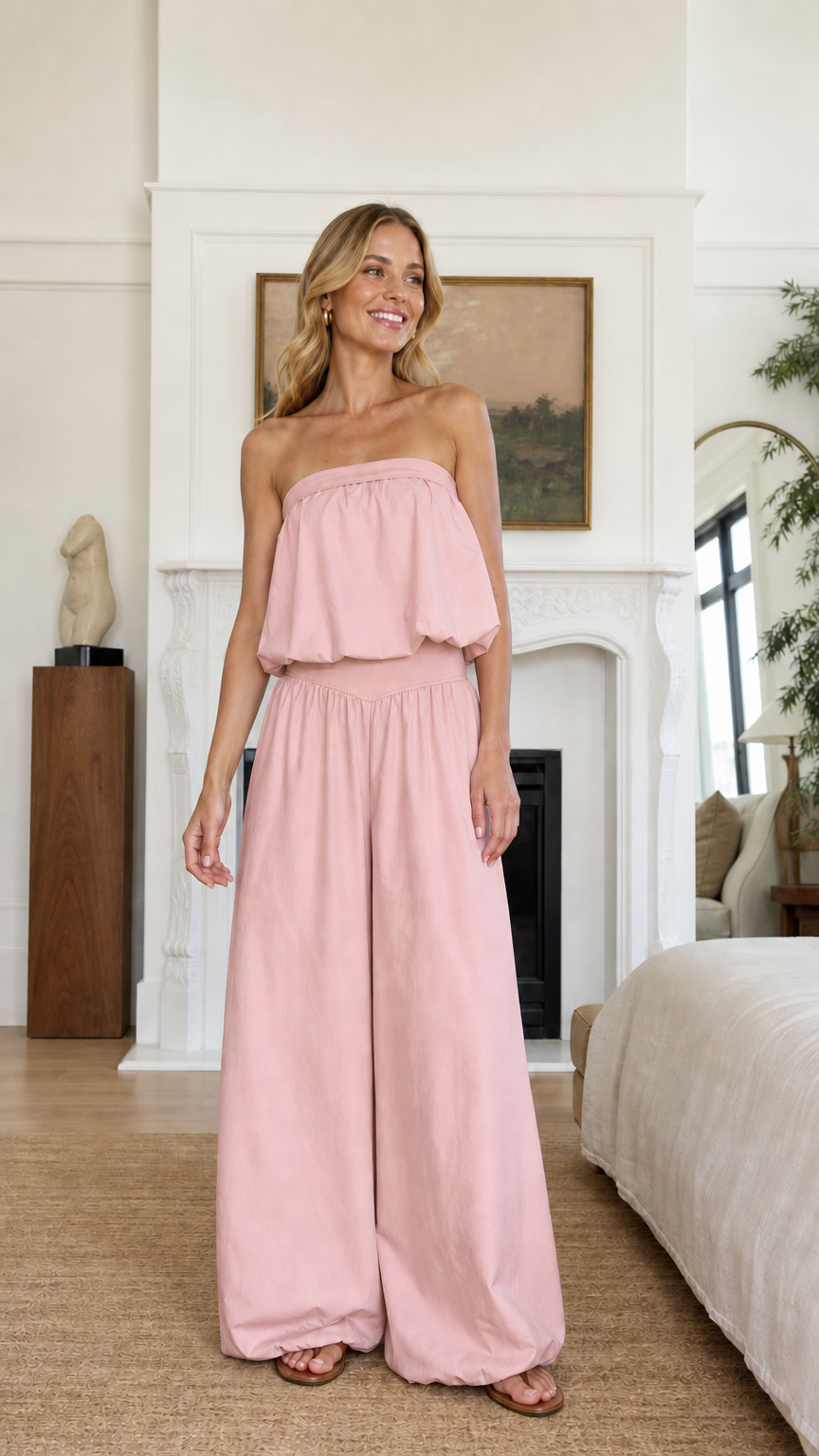Model wearing soft pink strapless ruffle crop top and wide leg pants set