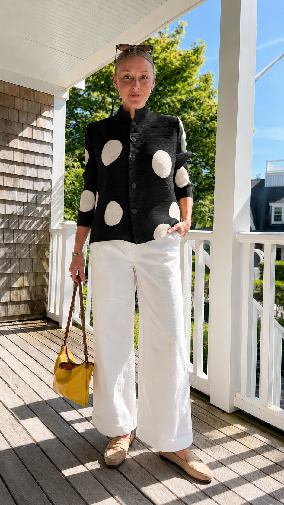 Front view of black pleated polka dot button-front jacket top with contrast dots