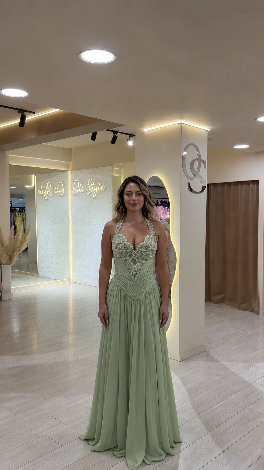 Model wearing sage green halter bodice evening gown with flowing skirt