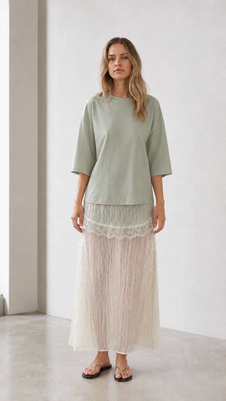 Front view of woman wearing sage green relaxed tee and matching skirt set