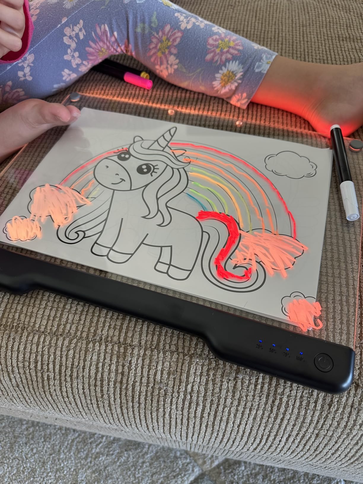 Child tracing a unicorn picture on the LED drawing board