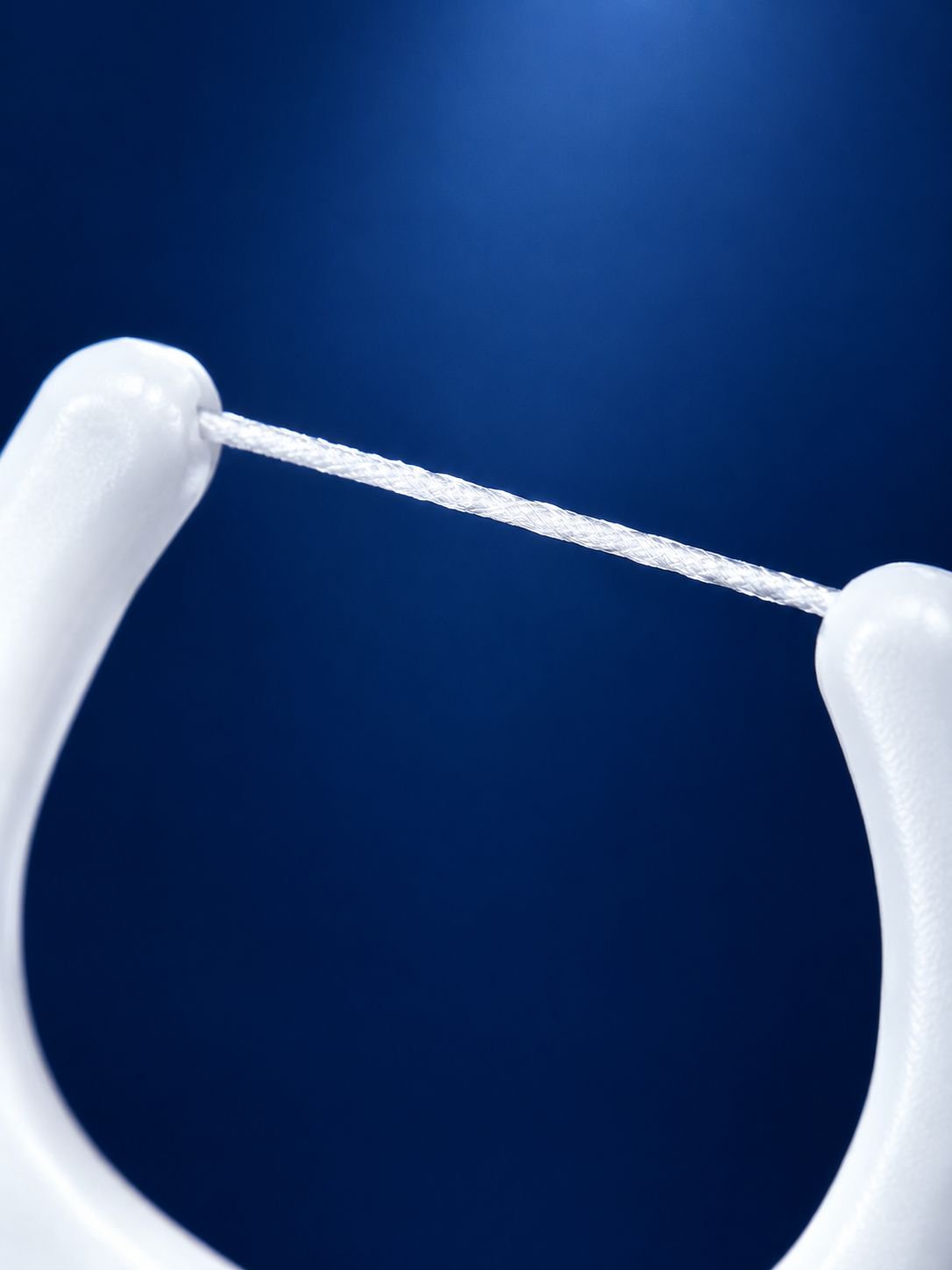 Polymer dental floss removing plaque between teeth