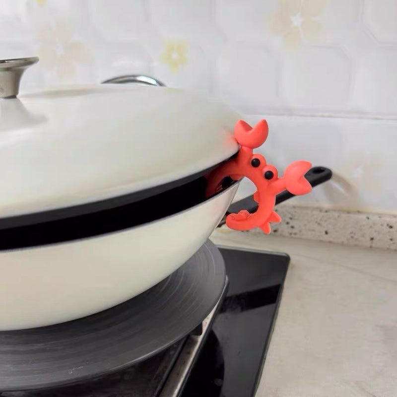 Crab silicone utensil holder supporting a cooking pan handle