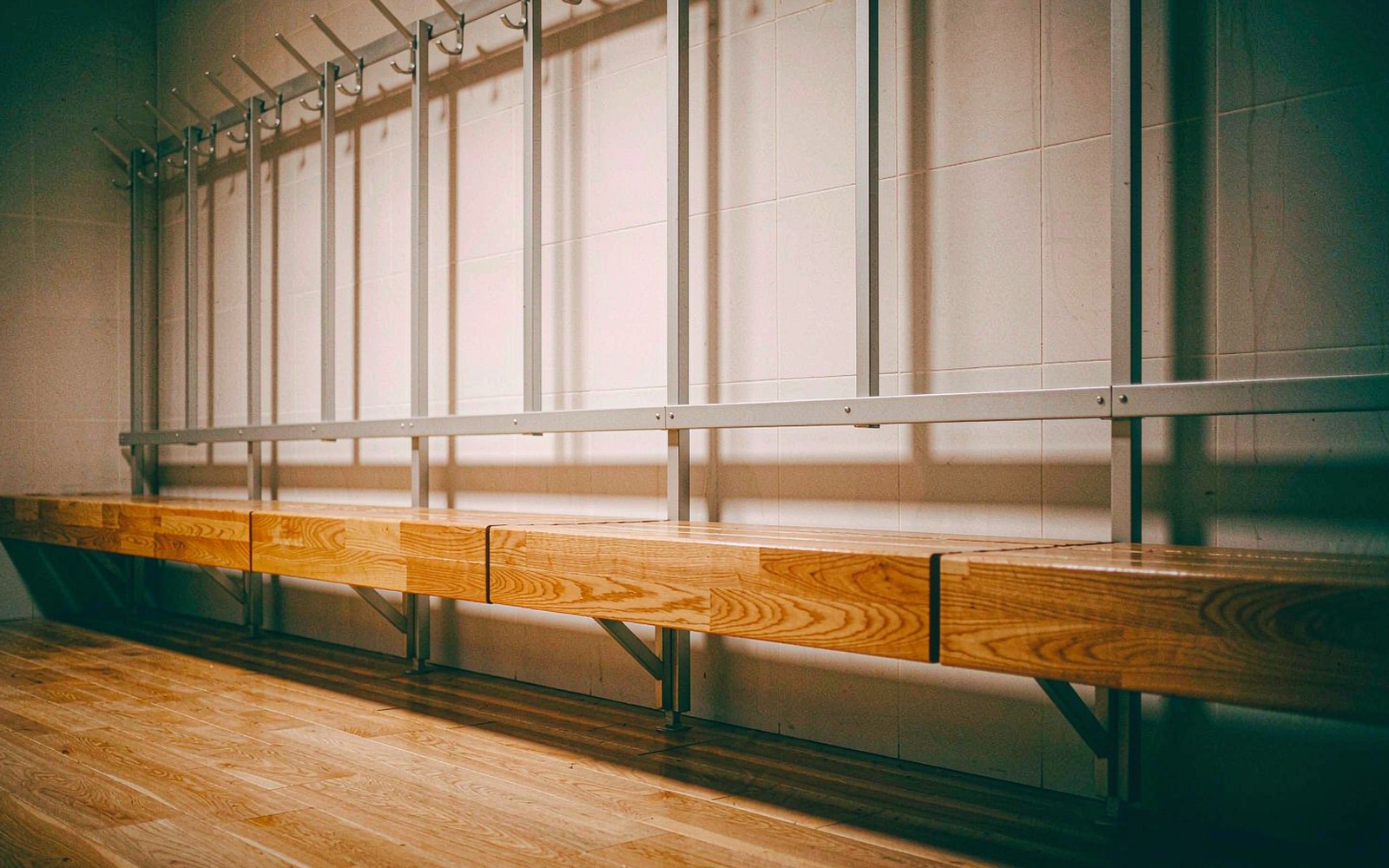 Empty dressing room with a wooden bench before match day