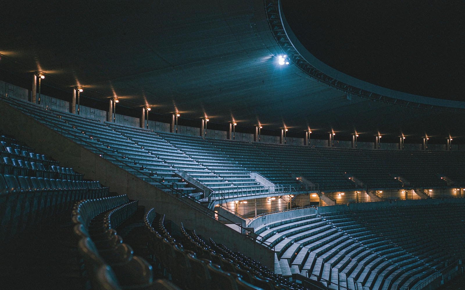 Empty stadium tiers under floodlights at night