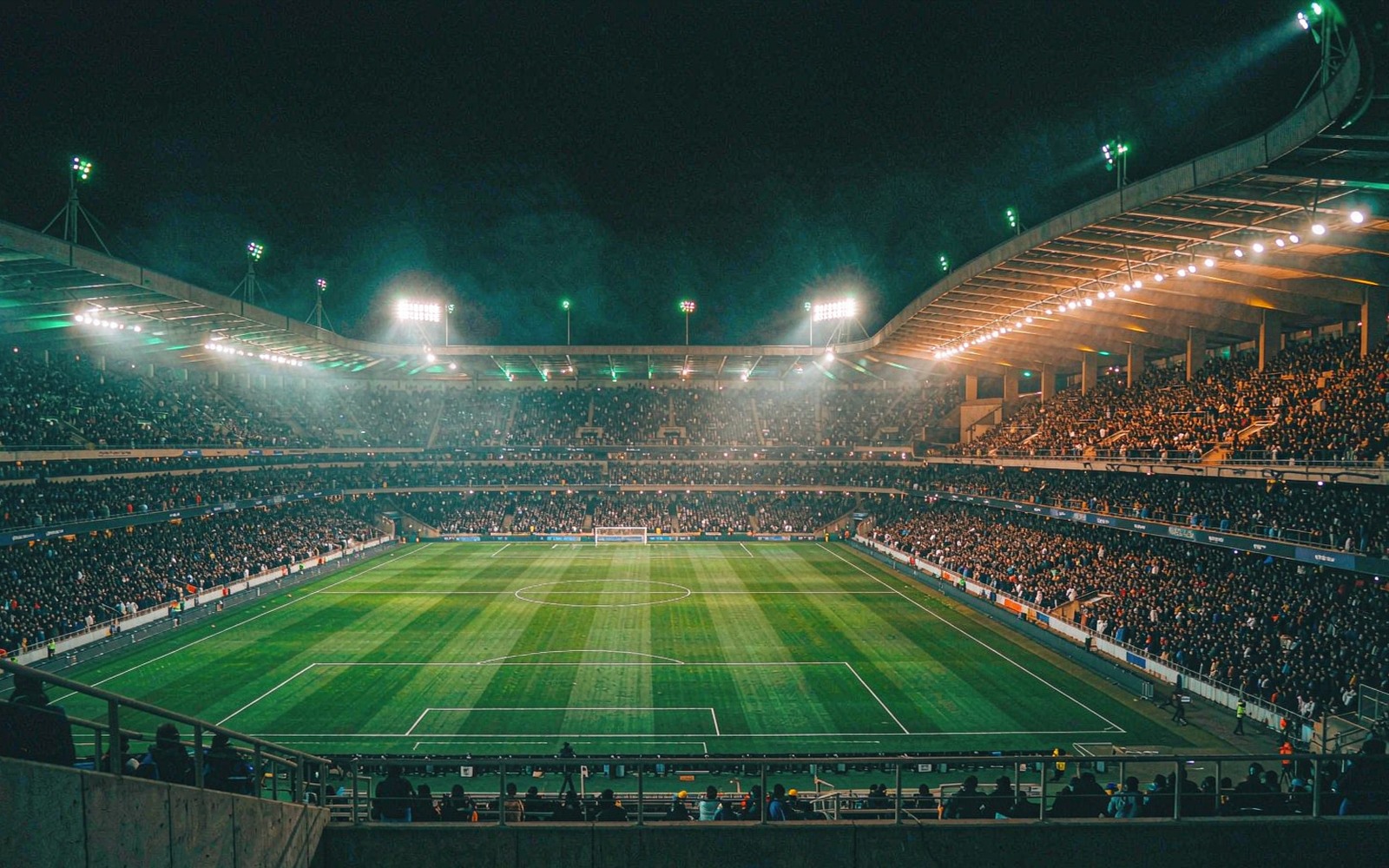 Wide view of a floodlit stadium at night