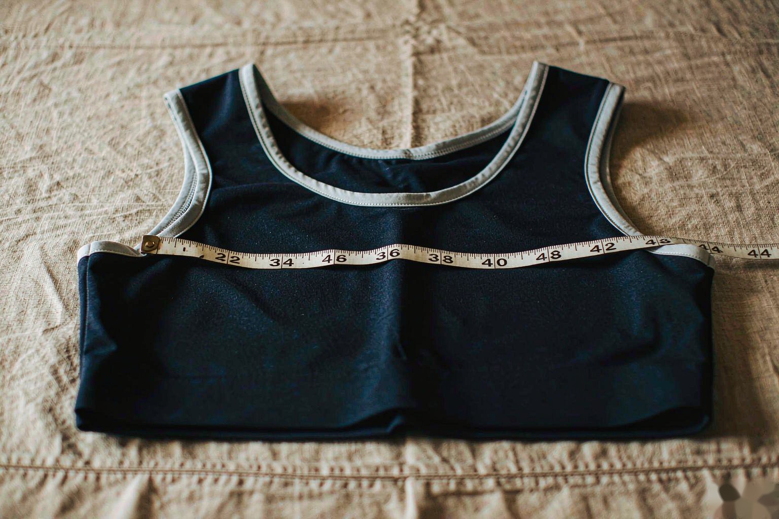 A measuring tape laid across the chest of a football jersey