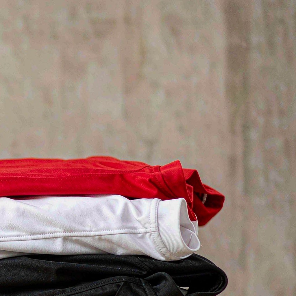 Stack of folded football shirts in team colours