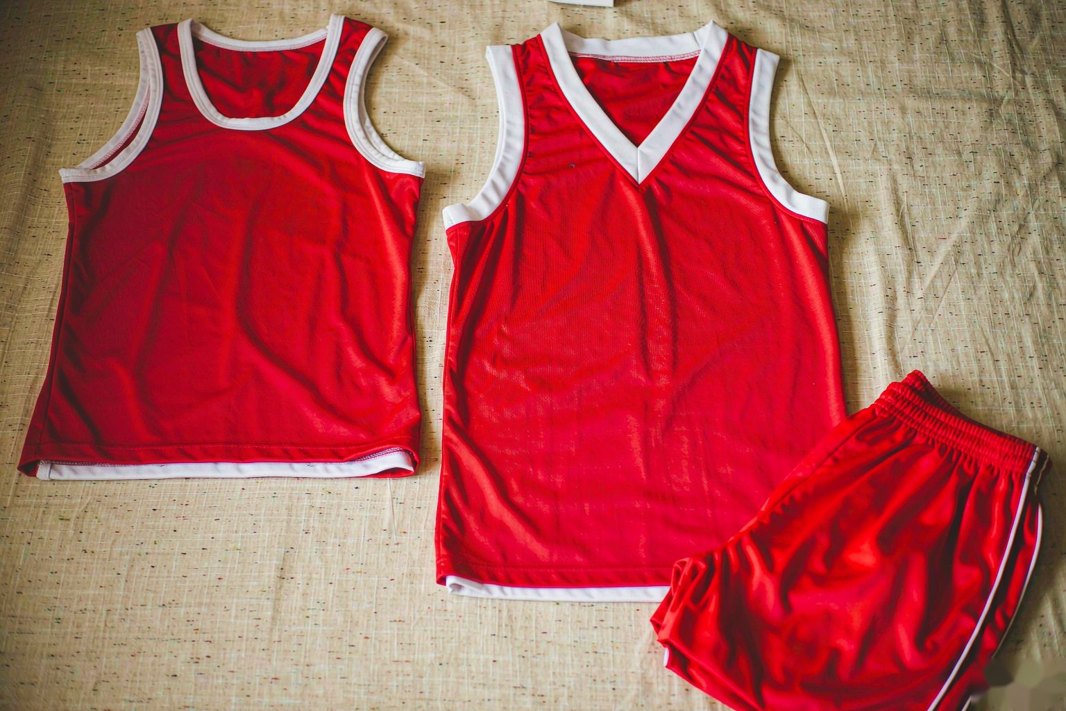 A boxy and a slim-cut basketball jersey laid side by side