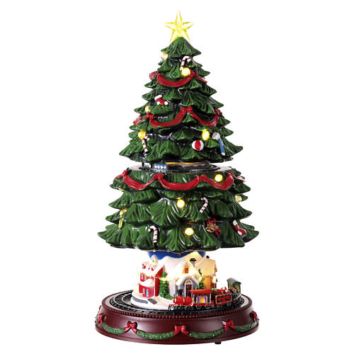 Christmas tree in its compact arrangement, with a miniature village and train at the base