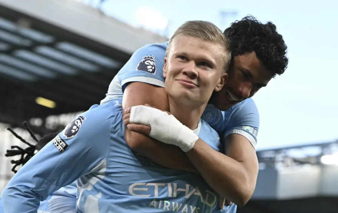 Manchester City players celebrating on the pitch at Anfield