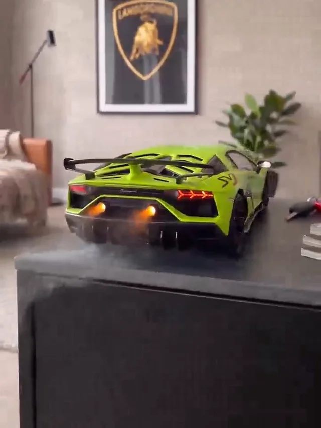 Green supercar on a dark cabinet with a black rear wing, red tail lights and mist at the orange-lit rear outlets