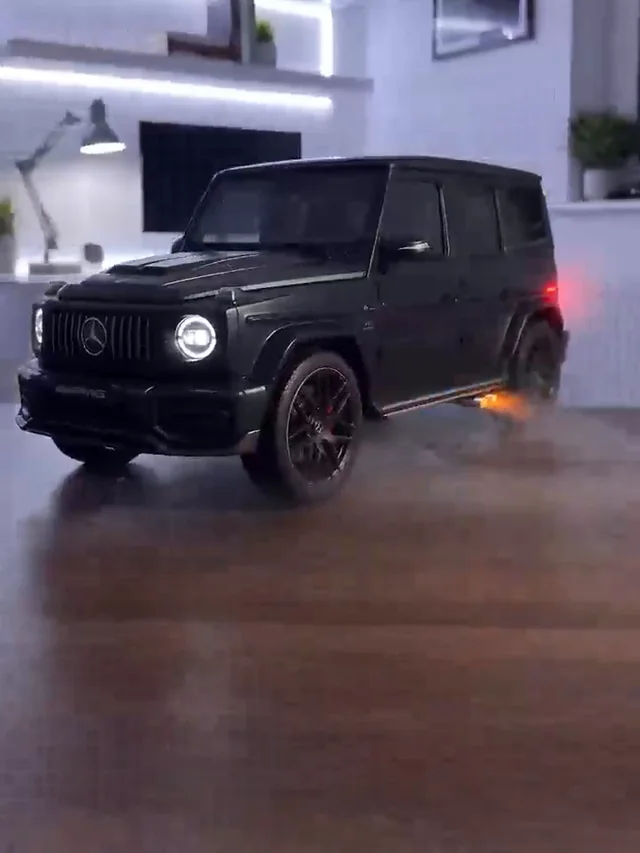 Black boxy SUV on a wooden tabletop with round white headlights and mist by the side step