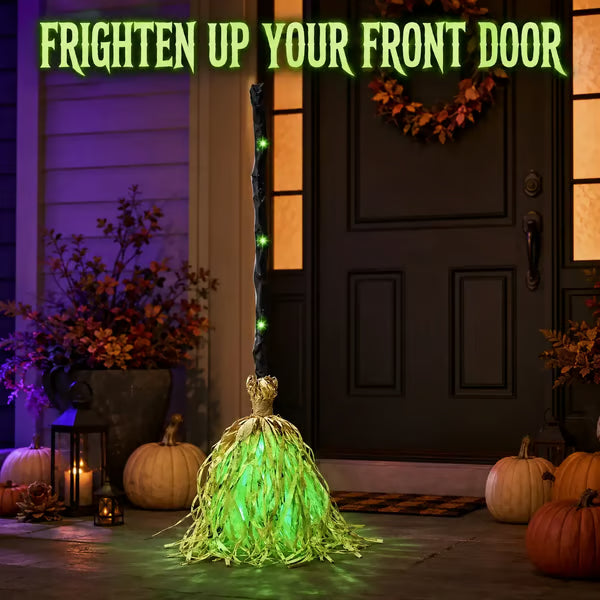 Light-up witch broom on a covered porch