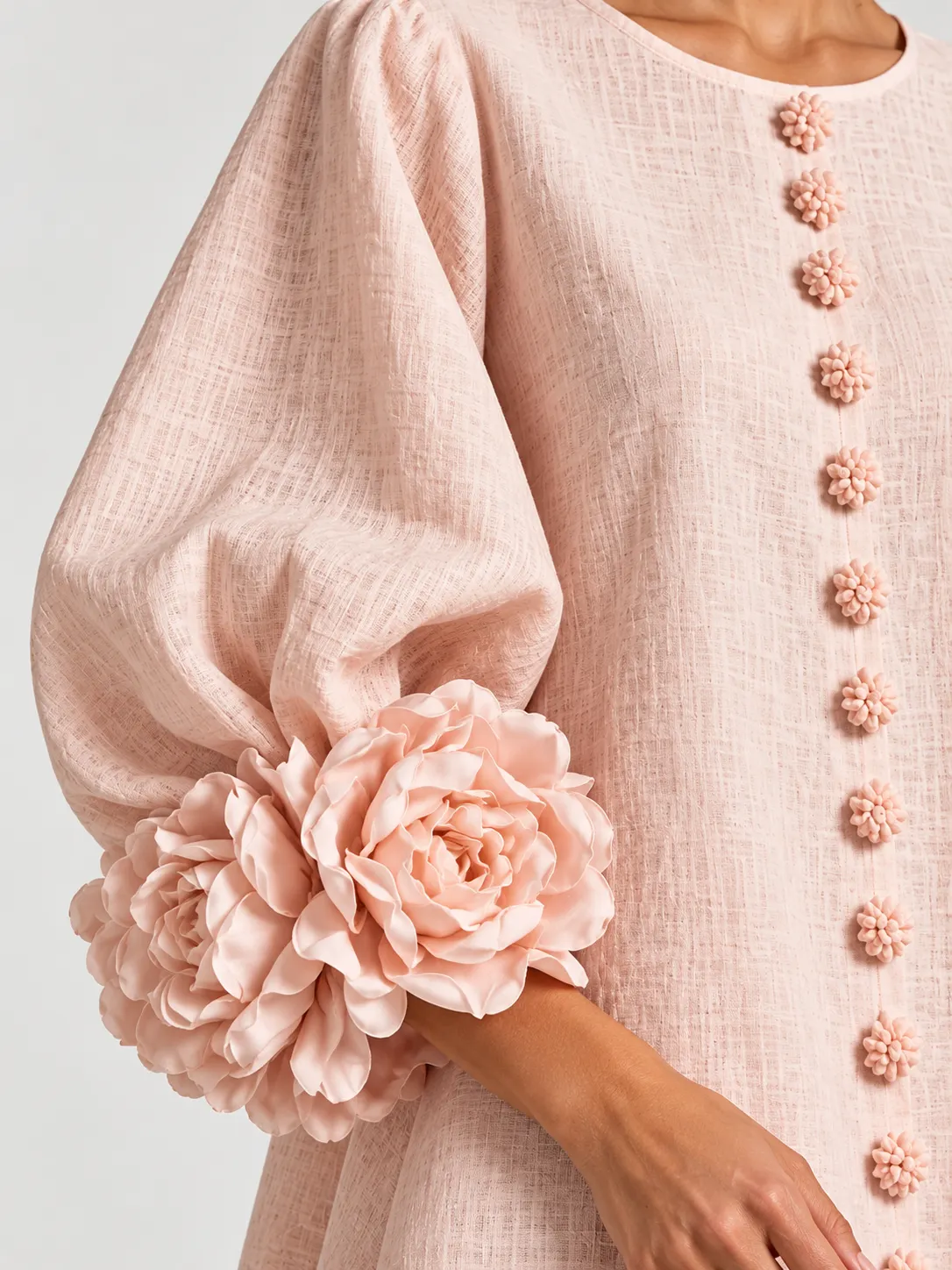 Close-up of the 3D floral cuff and lantern sleeve