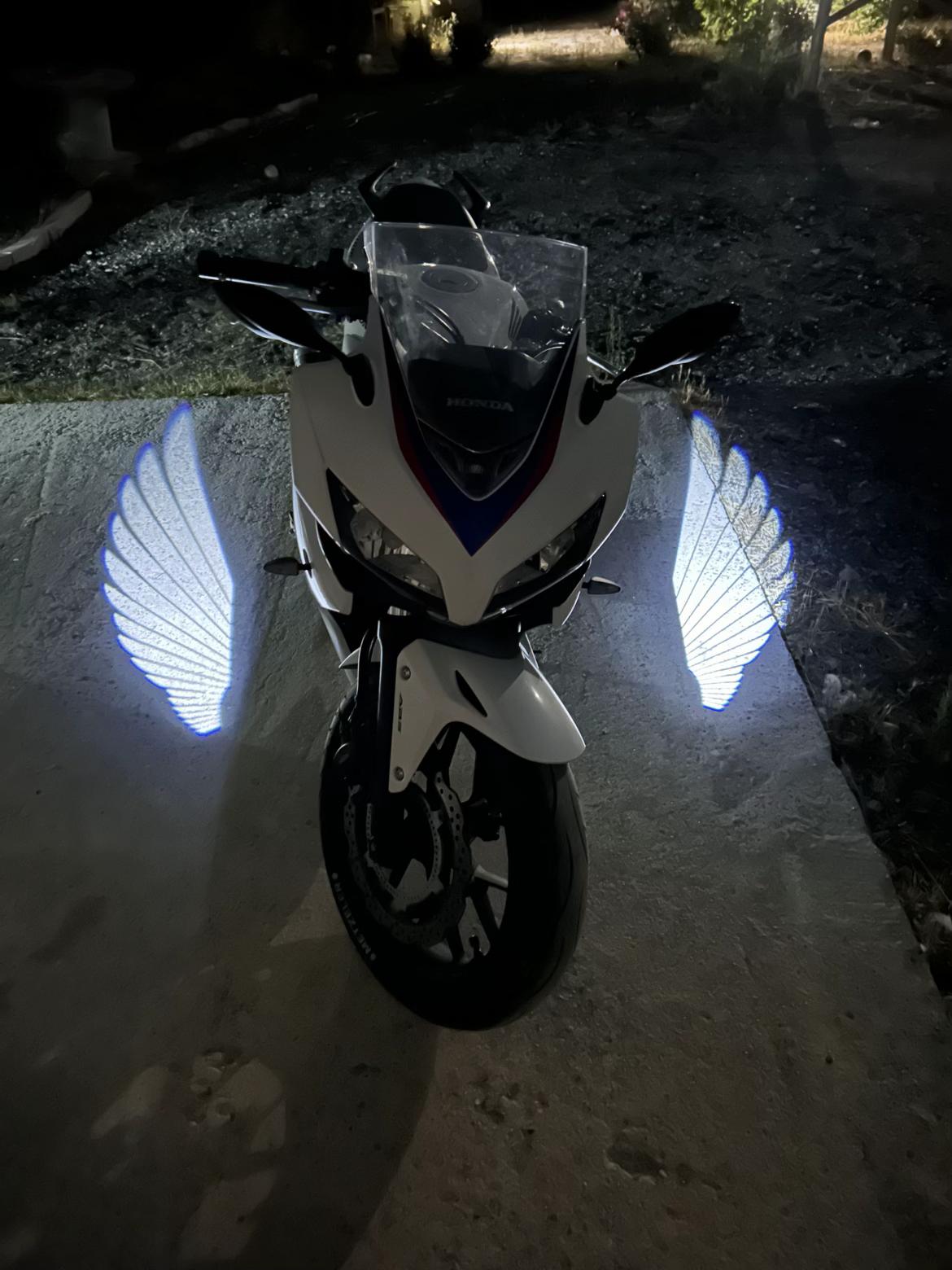 White wing projections beside a white motorcycle